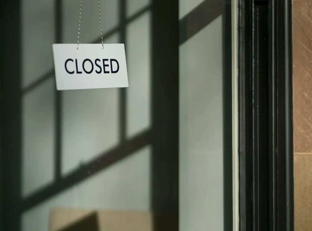 A closed sign hanging in a business window, the image behind startup failure-rate folklore