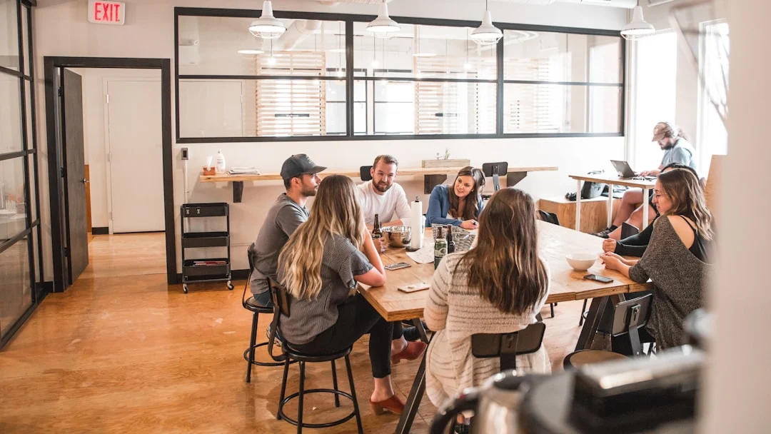 Startup team members talking around a table in a coworking space, the typical setting of a European accelerator or incubator