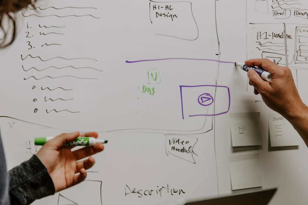 Two startup founders sketching an early product plan on a whiteboard